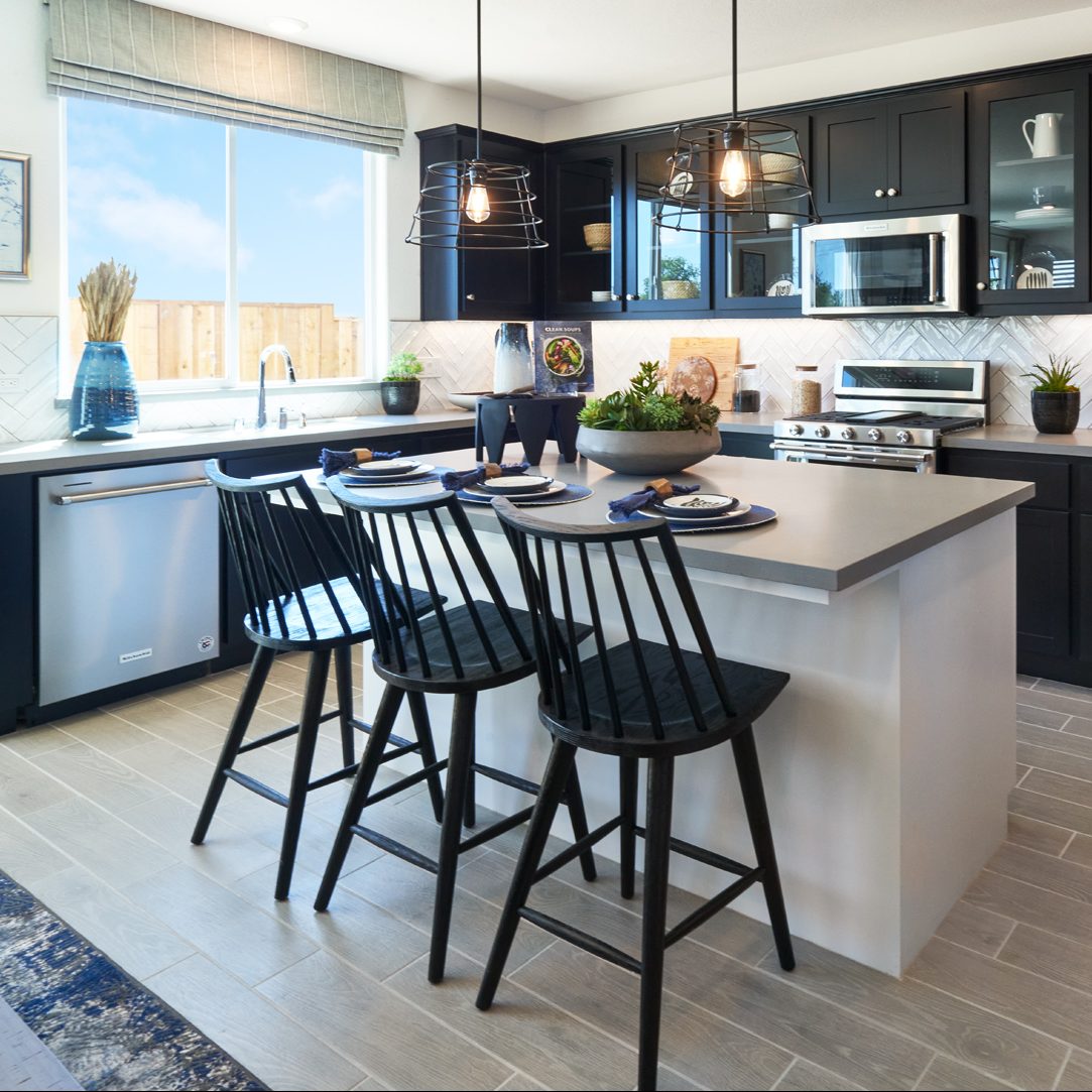 A kitchen with black cabinets and a White Island