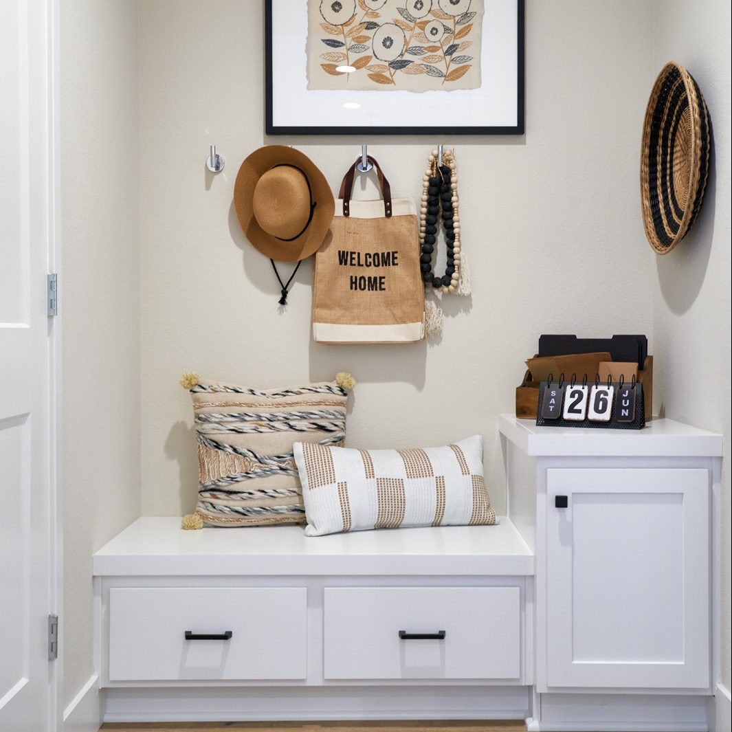 An entry with cabinets and hooks for hats