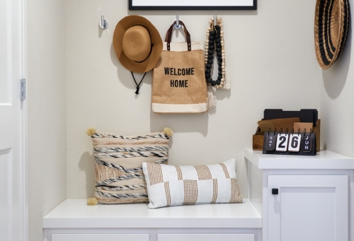 An entryway with a bench and hooks for hanging hats